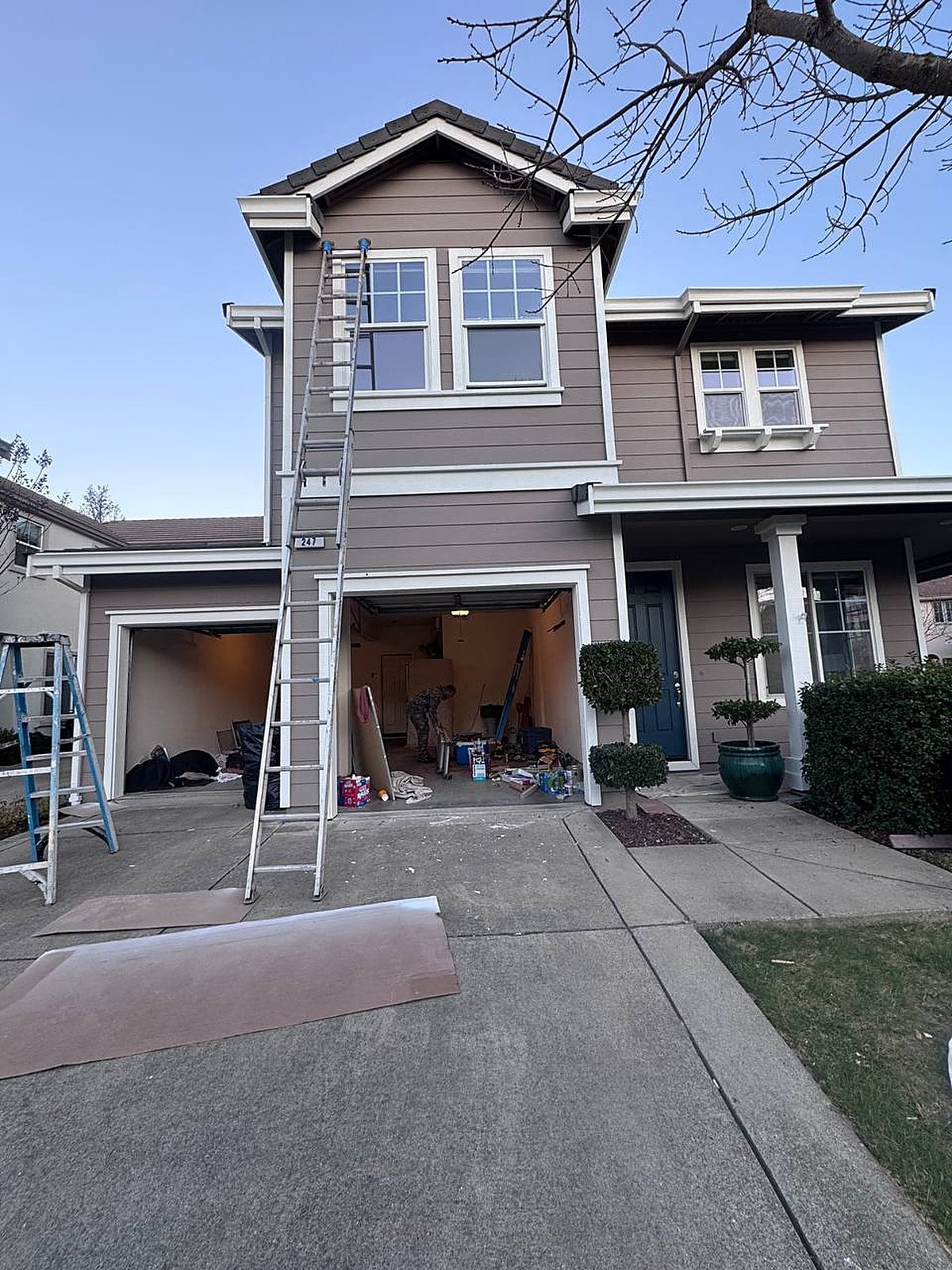 Two-story home during exterior repaint
