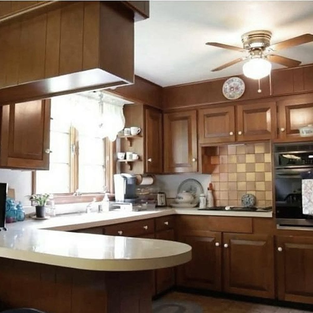 Kitchen before: dated oak cabinets, laminate peninsula and tile backsplash