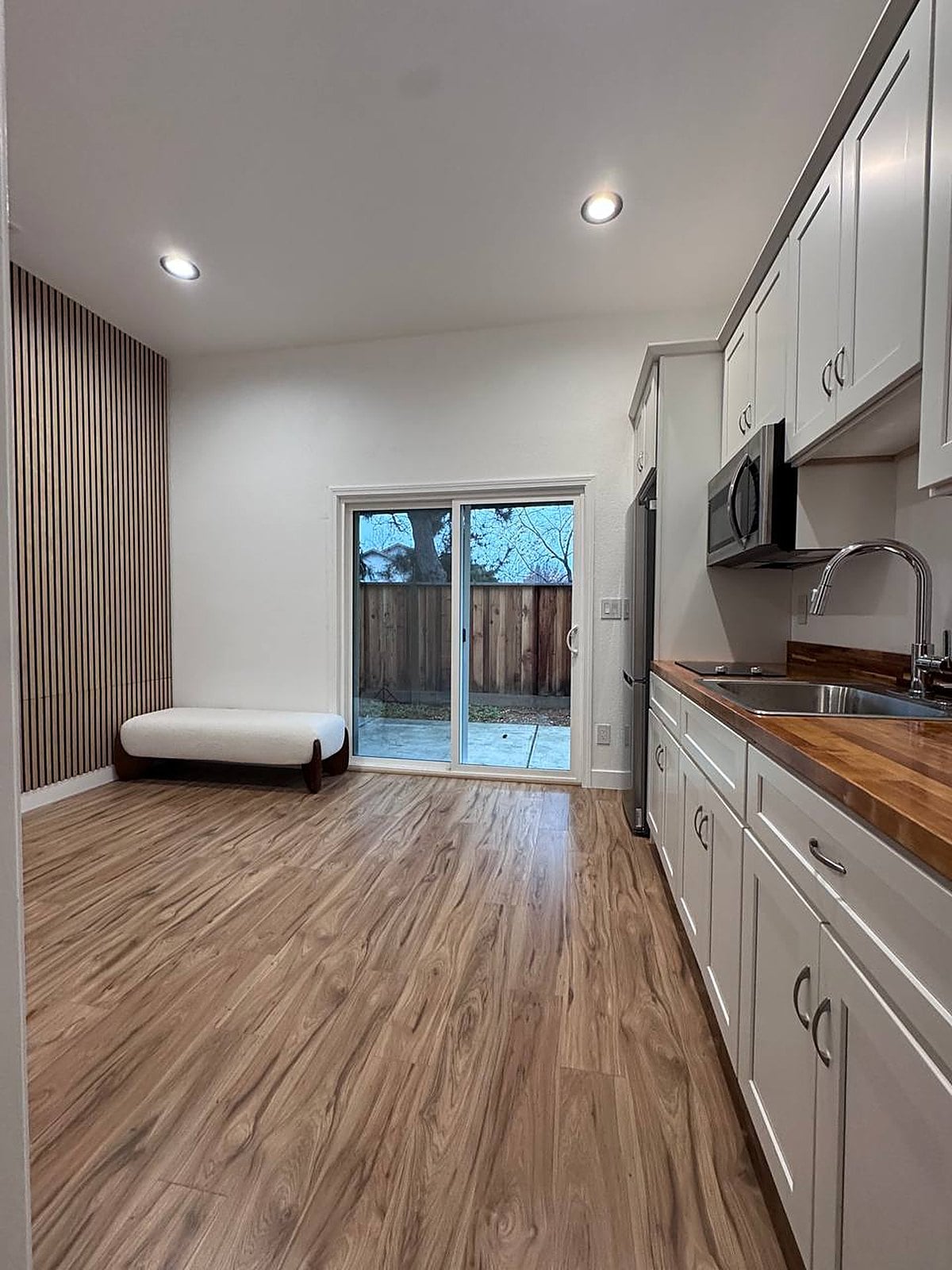 Bright remodeled living suite with walnut slat wall